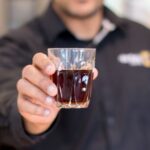 Barista sirviendo café a un cliente en una cafetería